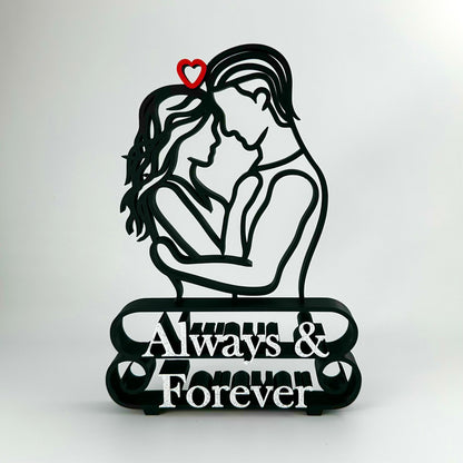 Decorative matte black plastic line art sculpture featuring a couple embracing, a red heart, and marble 'Always & Forever' text.