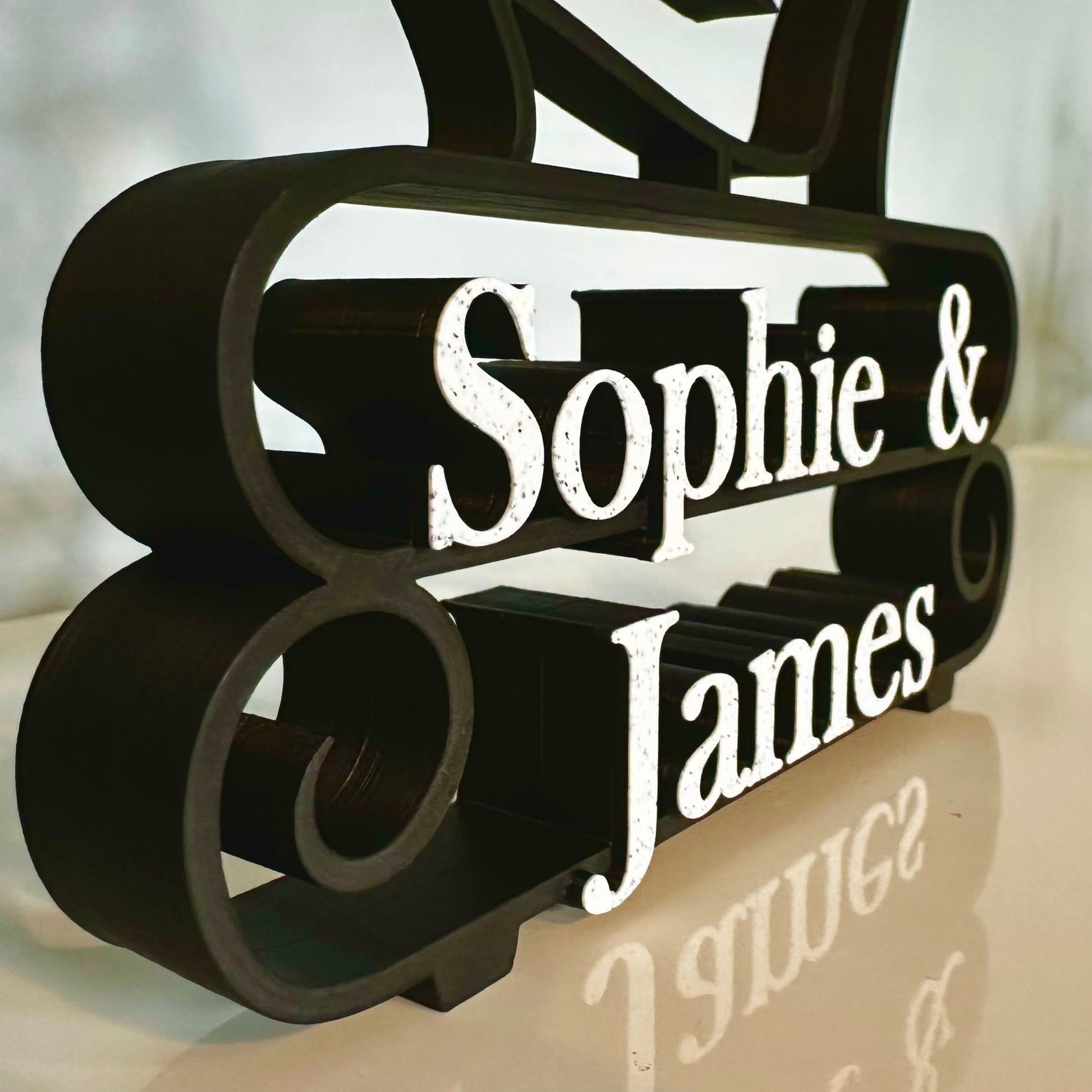 Beautiful matte black line art sculpture with 'Sophie & James' marble effect custom text 