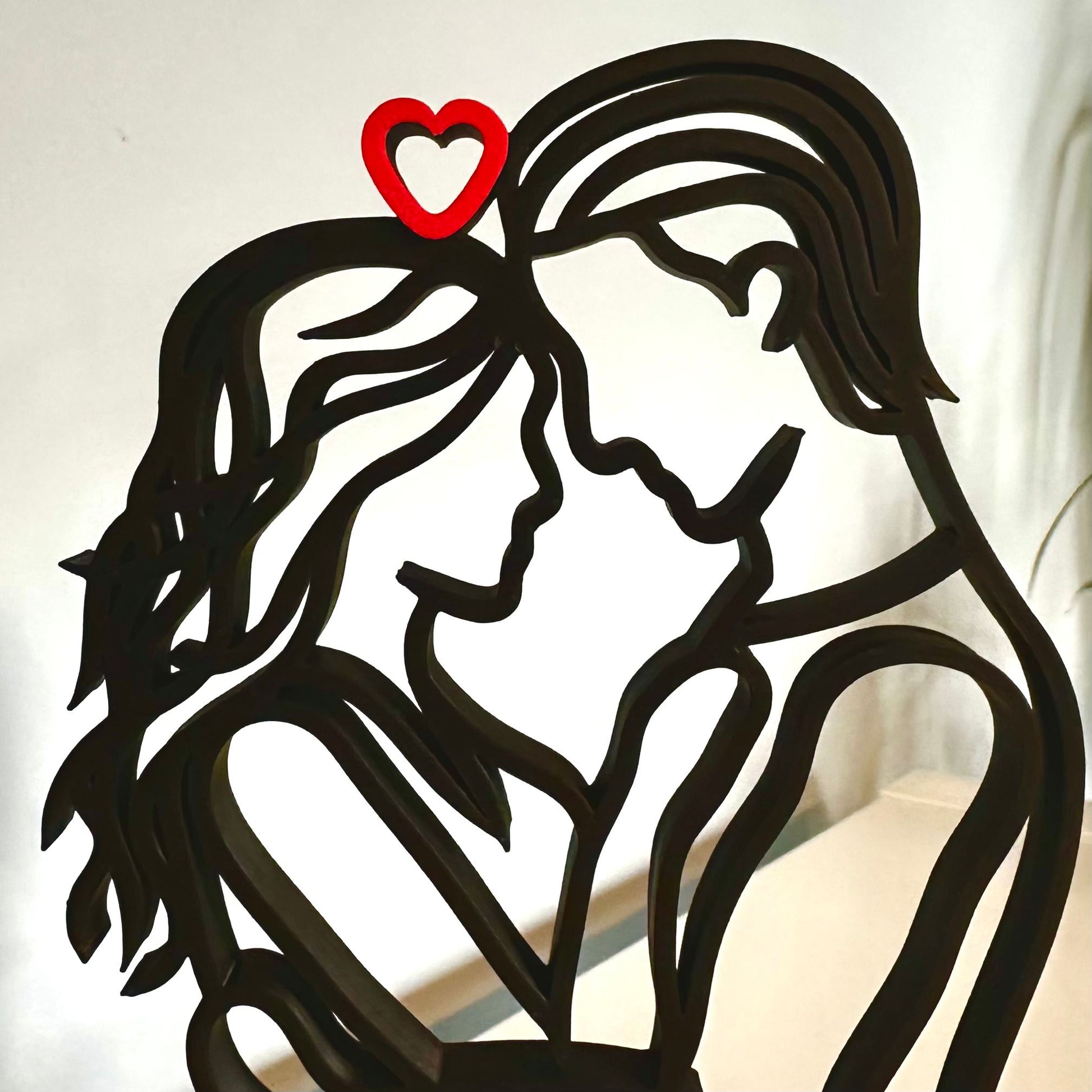 A zoomed-in view of the male and female faces of this beautiful 3d-printed line art sculpture