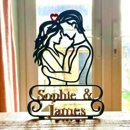 Gorgeous line art sculpture of a couple embracing and 'Sophie & James' marble effect text underneath, silhouetted against a window