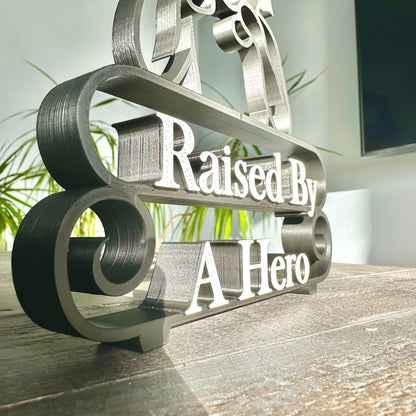 Modern plastic line art sculpture - zoomed in on the text 'Raised By A Hero', 3D-sculpted.