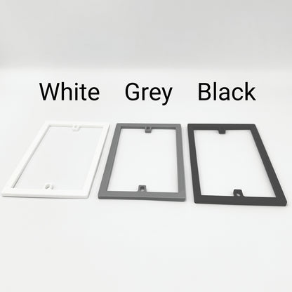 Three rectangular socket spacer / extension frames in white, gray, and black with labels above each to show the different colours available.