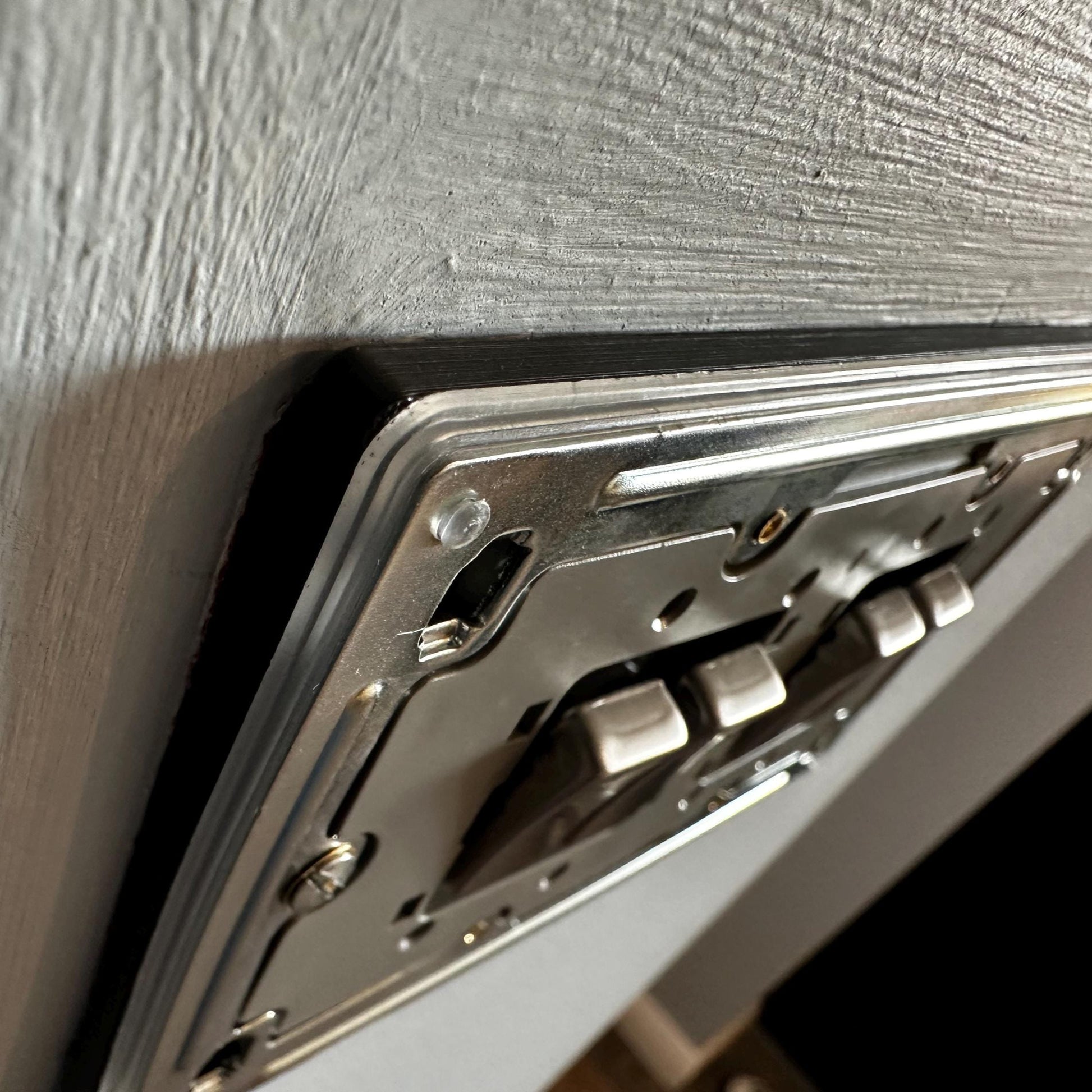 Close-up of a double gang lightswitch with faceplate cover removed, showing how a socket spacer can be used to give extra depth between the backbox (or wall) and faceplate.