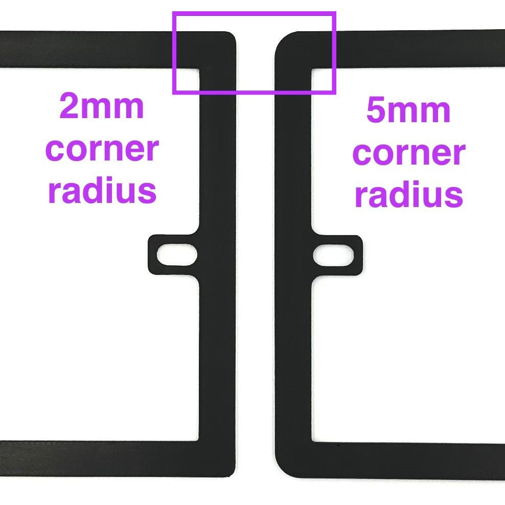 Close-up of two black socket spacers / extension frames with different corner radiuses, showing there are options for how rounded the corners of the plates are (2mm radius or 5mm radius).